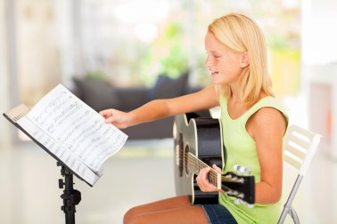 Girl Playing Guitar with Sheet Music