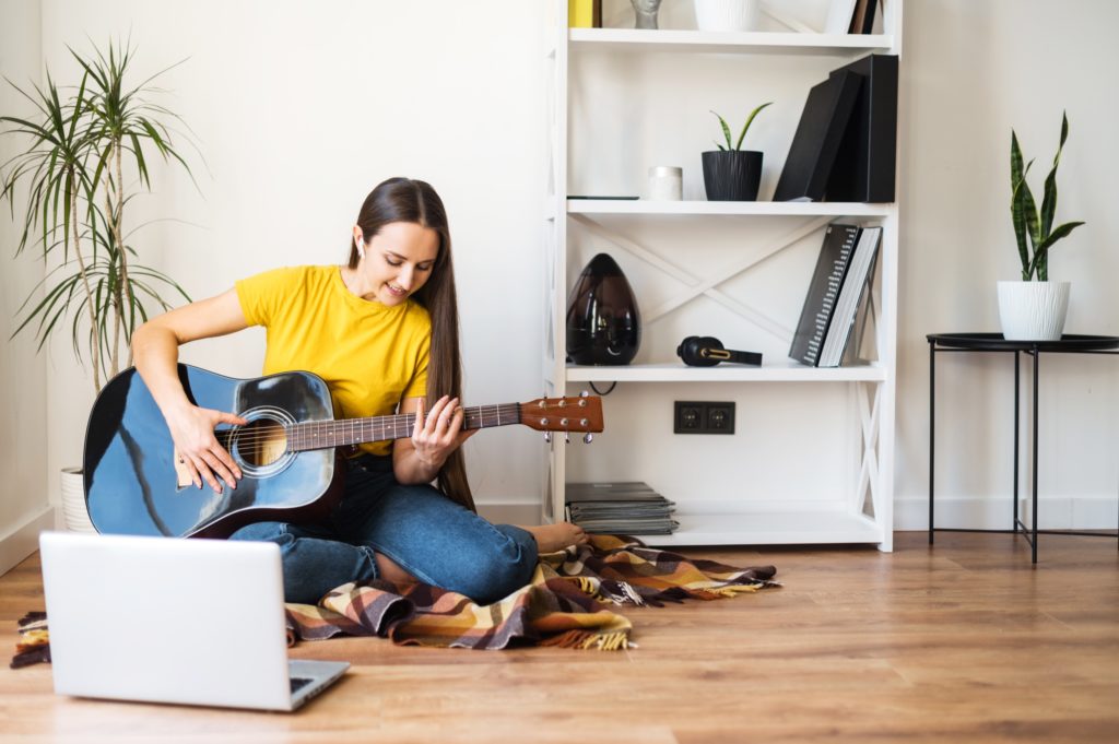 Image of a young woman learning the Am7 guitar chord